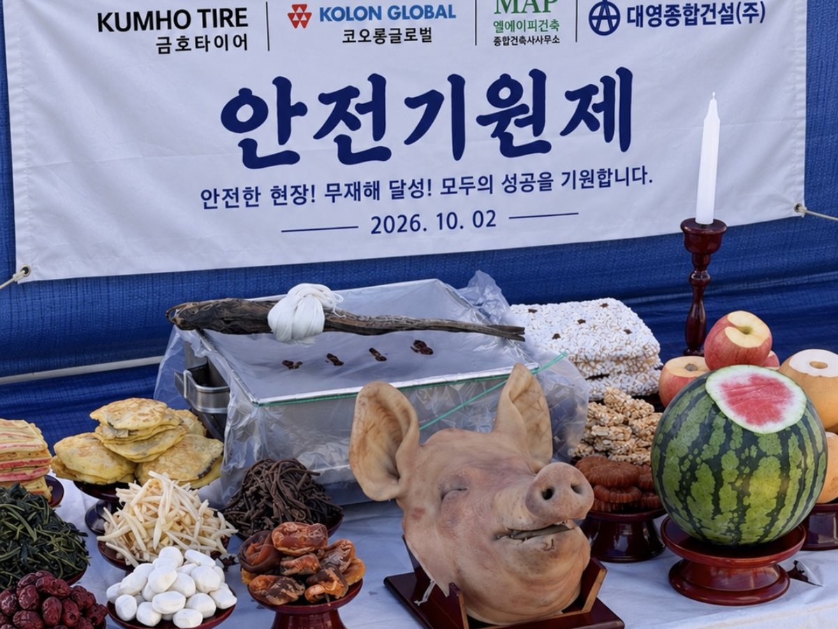건설현장 안전기원제 고사상 — 현수막 앞 돼지머리와 전·나물·과일을 올린 야외 상차림