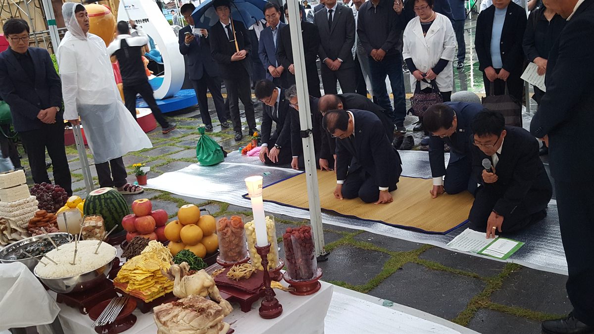 우천 중 진행된 기관 행사 — 내빈들이 재배하는 모습
